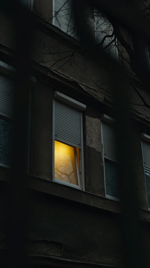 light shining from window next to a dark building