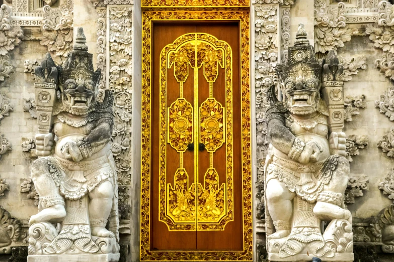 this doorway has statues and golden colored doors