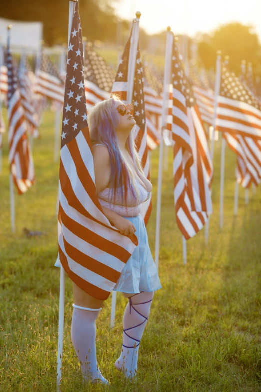 a woman in a short dress next to american flags