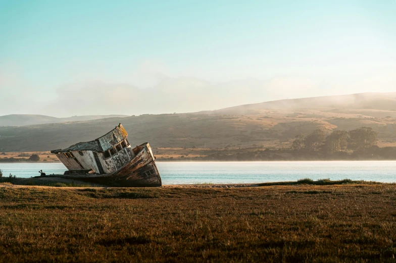 a boat laying in the grass on the shore