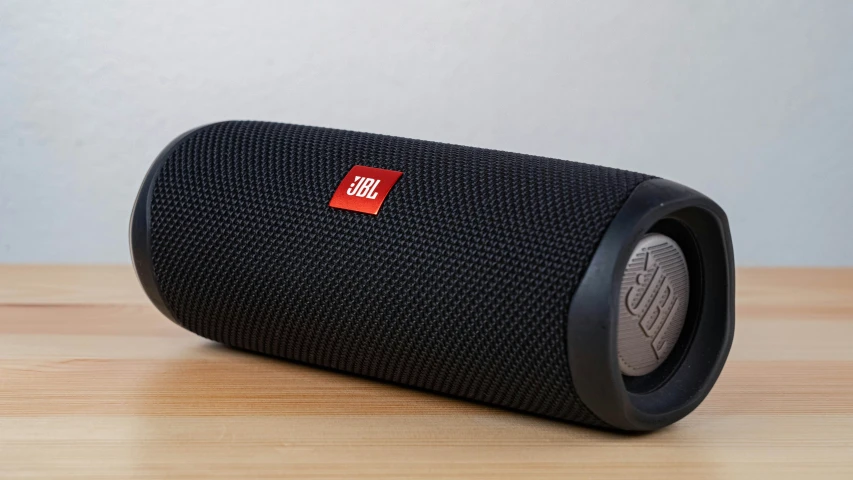 a black speaker on top of a wooden table