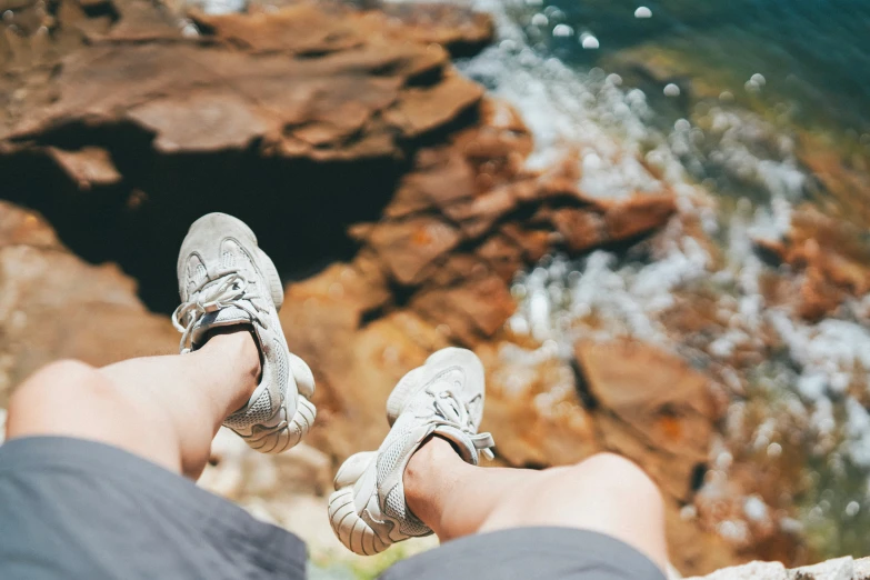 someone is standing on the rocks and water below