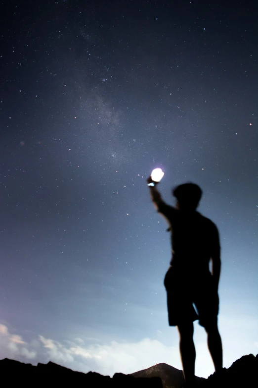 the man is using his cell phone under the stars