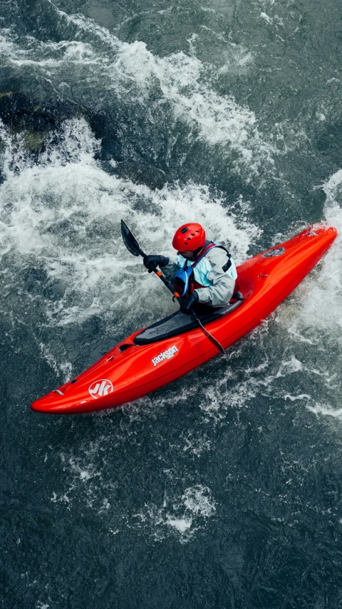 the kayaker is riding through a wave in the ocean