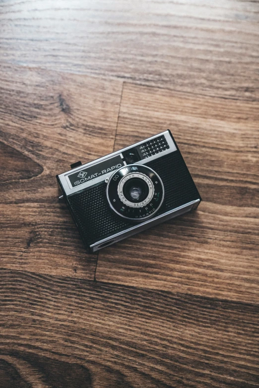 an old camera on top of a wooden table