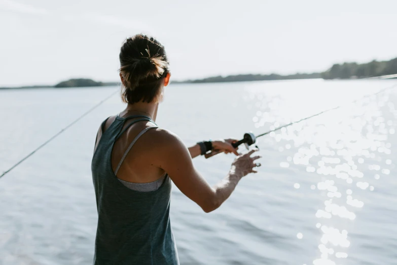 a woman standing on a boat holding onto a fishing rod