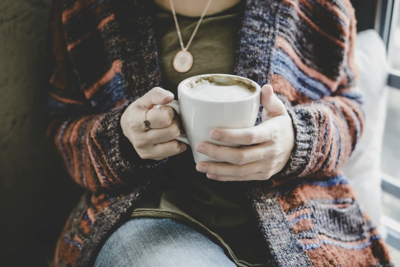 someone sitting down and holding a cup