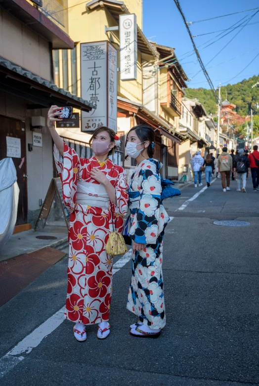 two women dressed in oriental garb standing on the street