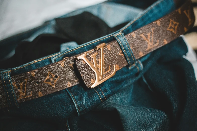 the back pocket of a pair of blue jeans with a gold buckle