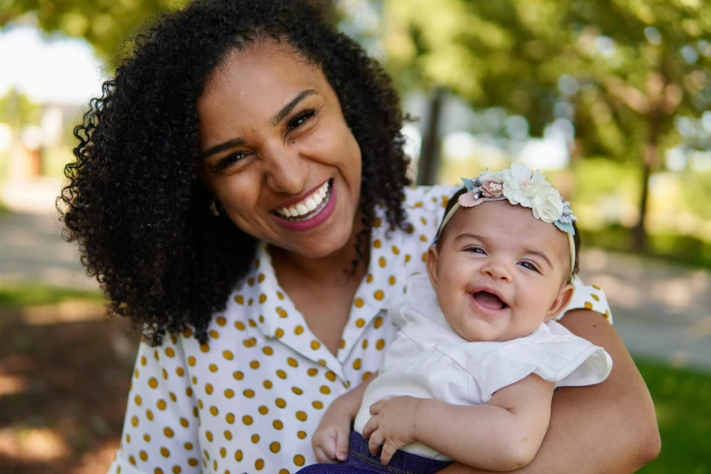 a woman smiling and holding a child