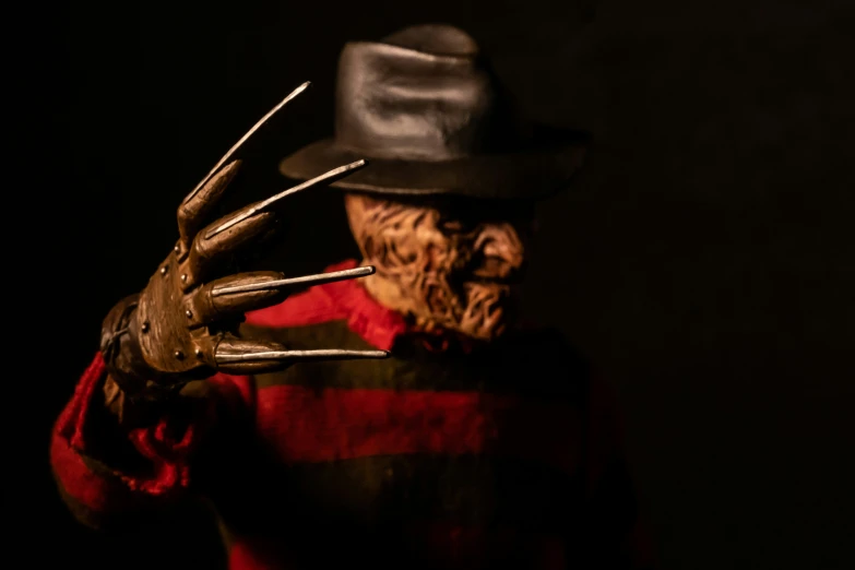 a person in a creepy mask and long metal hands