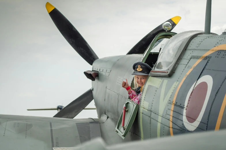 a woman is sticking her head out the window of a plane