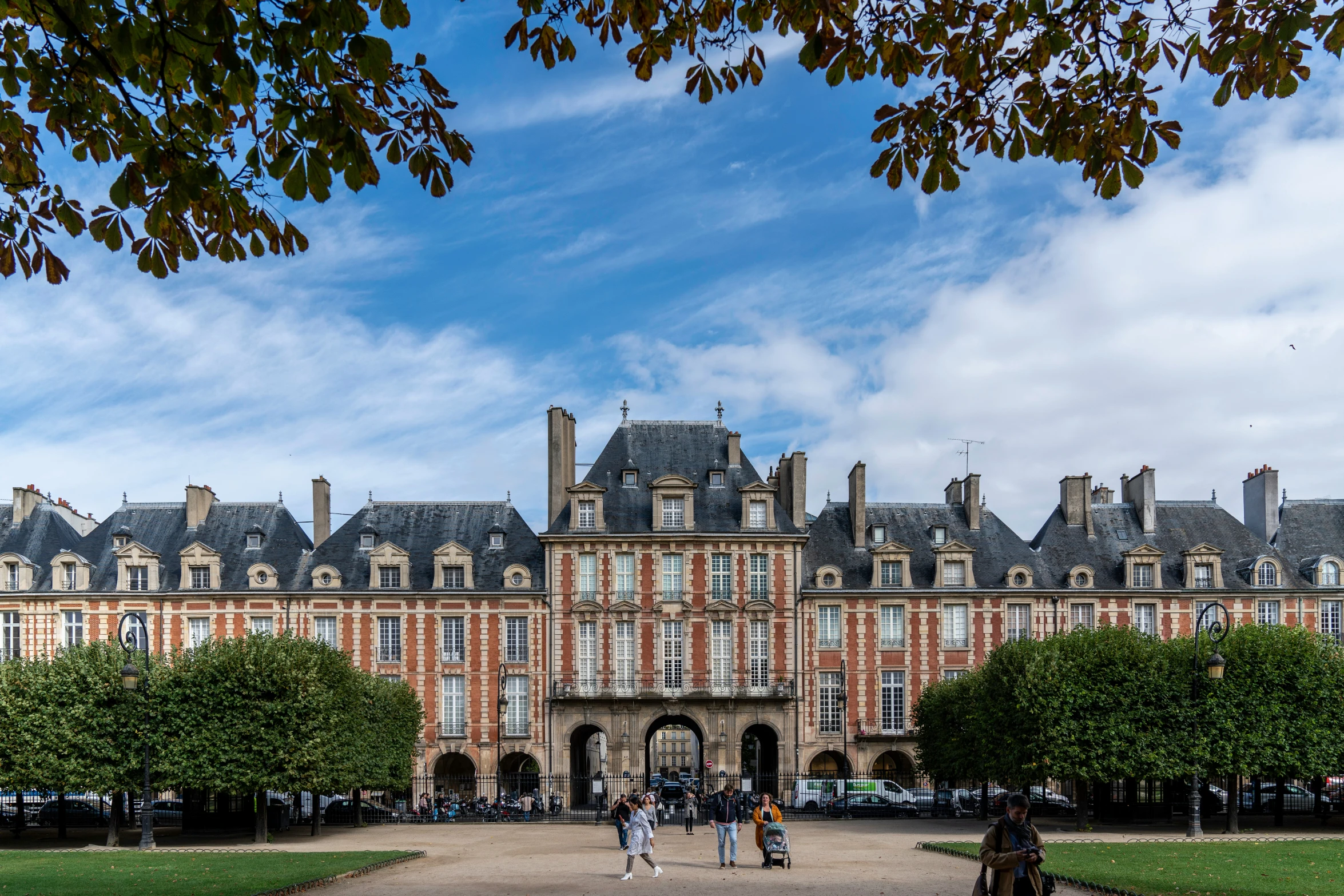 people are standing in front of a building with trees around