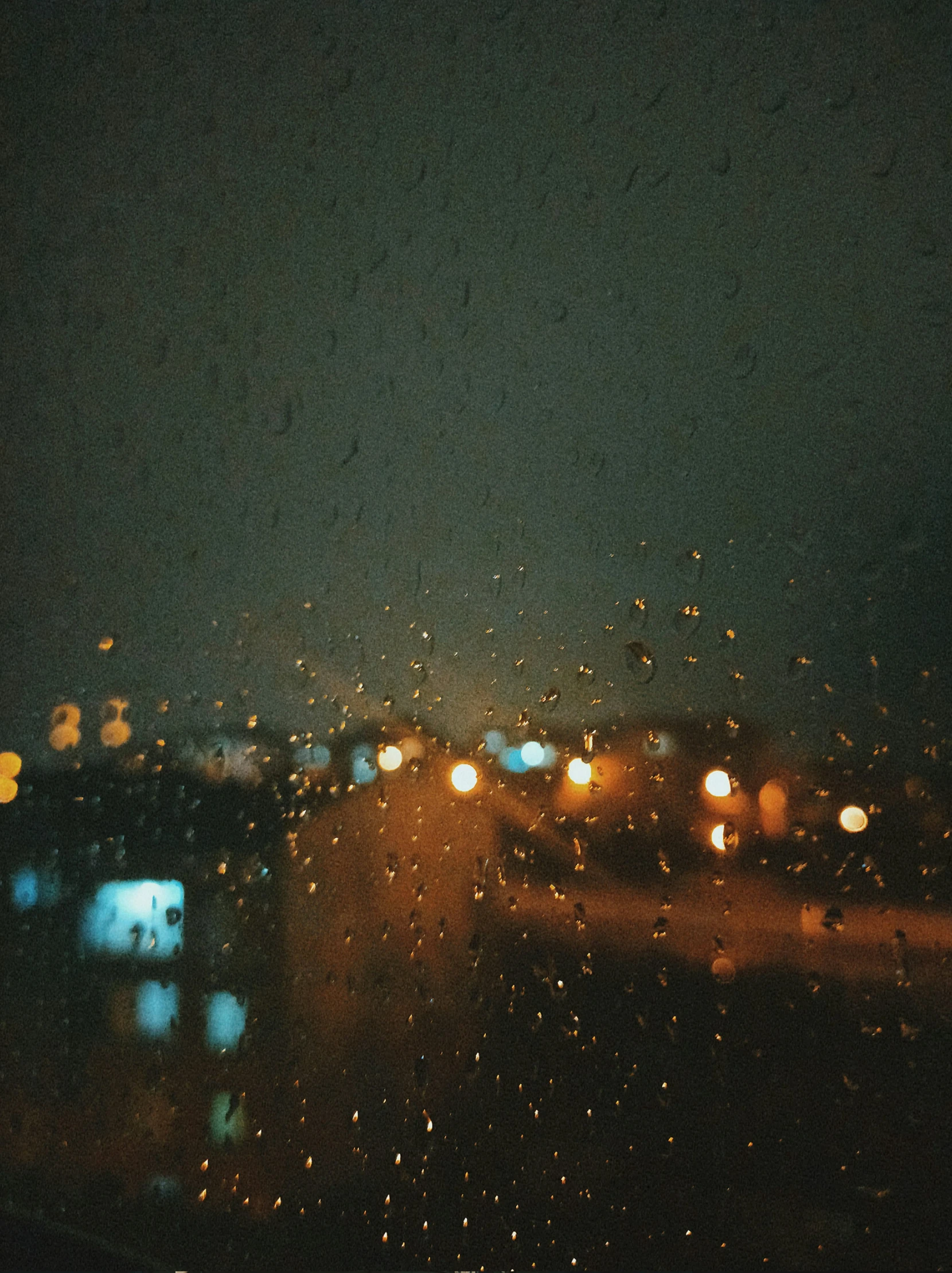 a window with rain drops at night from inside