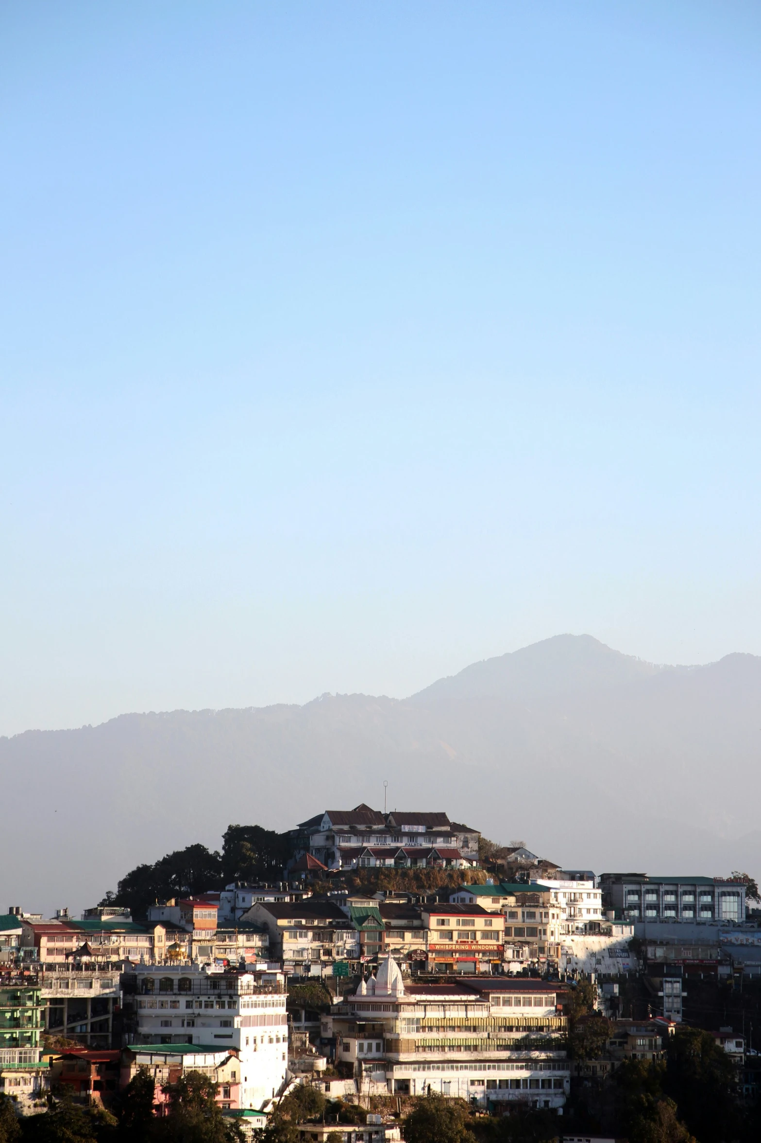 city scene of houses and hills near a mountain