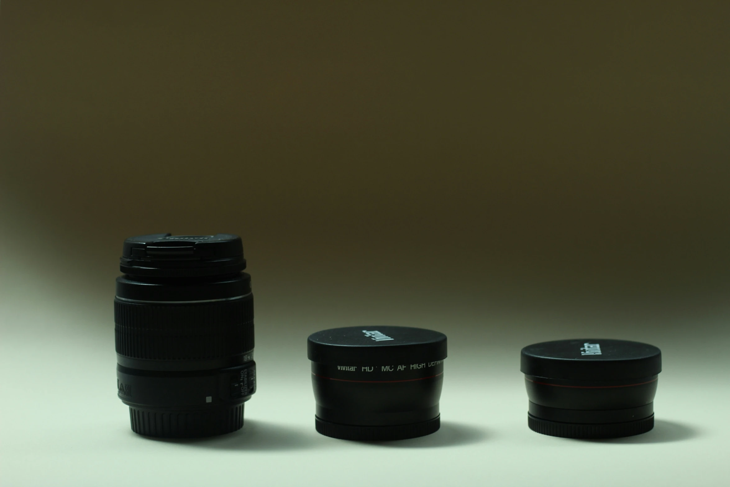 a close up of a camera lens next to a cup