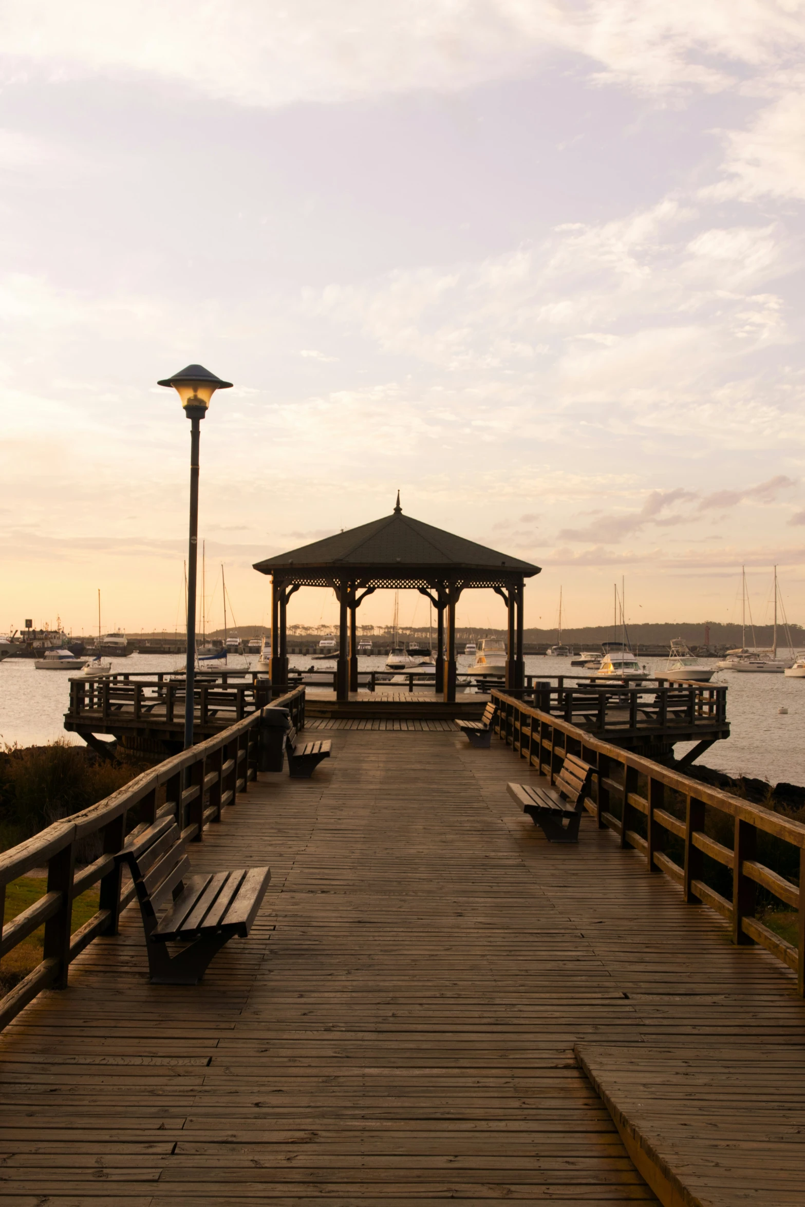 the boardwalk has several benches and a lantern on it