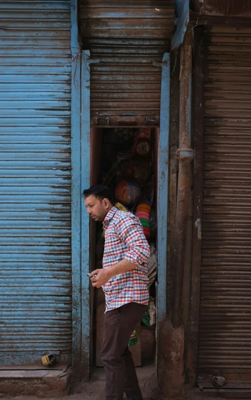 a man with a red and white checkered shirt is walking