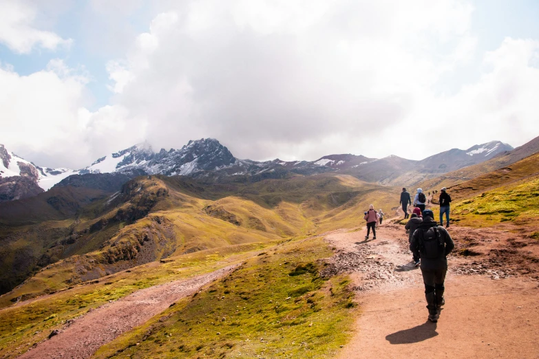 people walking on the trail in the mountains