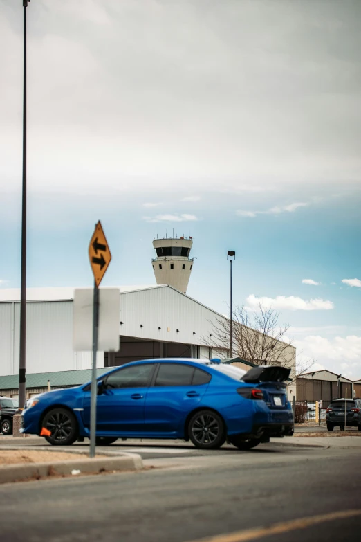 a blue car sitting in front of an airport