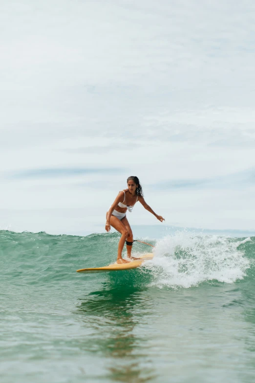 a girl riding a wave on a surfboard
