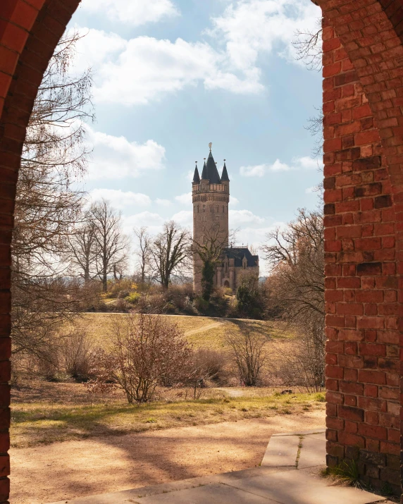 an archway in the wall leading to a building with a clock on it