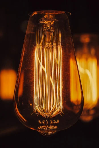 an old fashioned light bulb is lit up at night