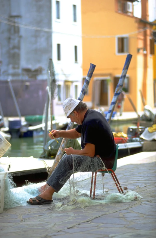 the man is sitting on a chair and trying to fish