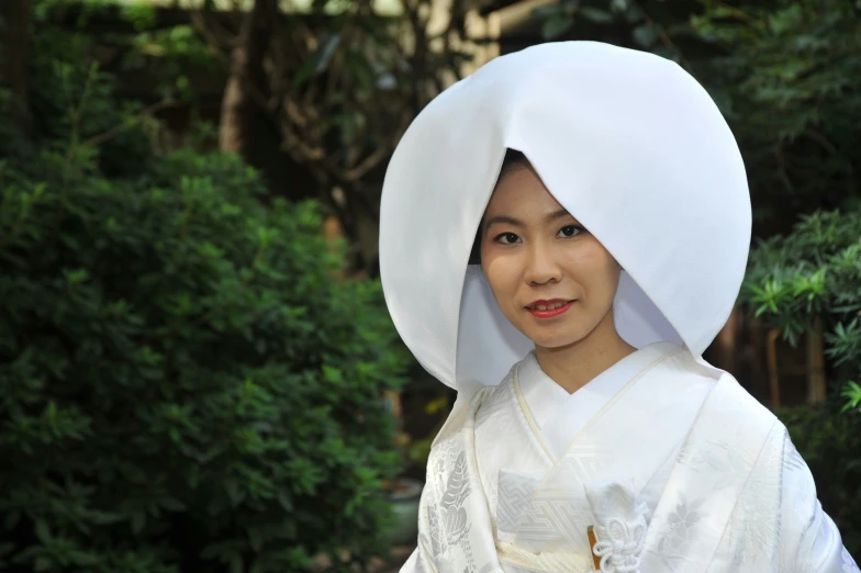 a young lady with white head scarf and white gown