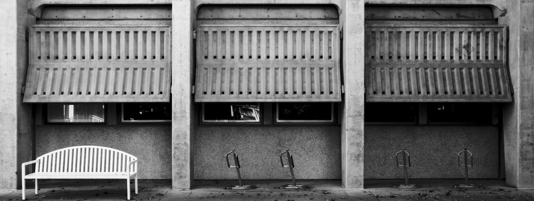 white bench and multiple windows near tall wall