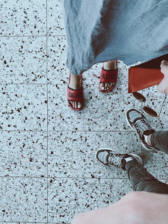 people standing on white speckled tile wearing sandals