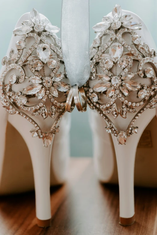 a pair of white wedding shoes with beading and ribbons