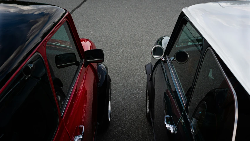 two cars with windshield covers sit in a parking lot