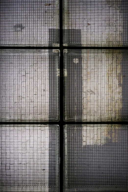 a black wall with squares on it in a room