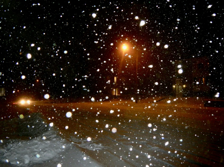 a street at night with cars driving down the road, in the dark