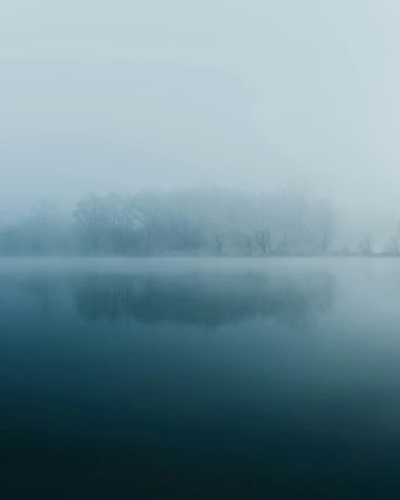 a body of water on a foggy day