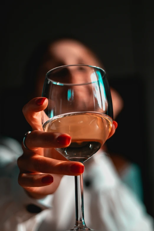 someone holding up a glass of wine for a drink