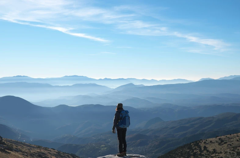 a woman standing on the edge of a cliff