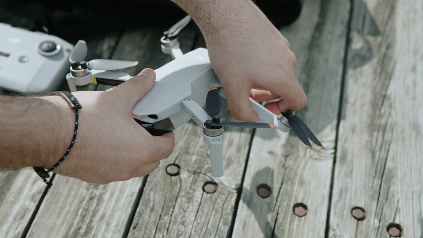 a person holding a small device near other people on a wooden pier