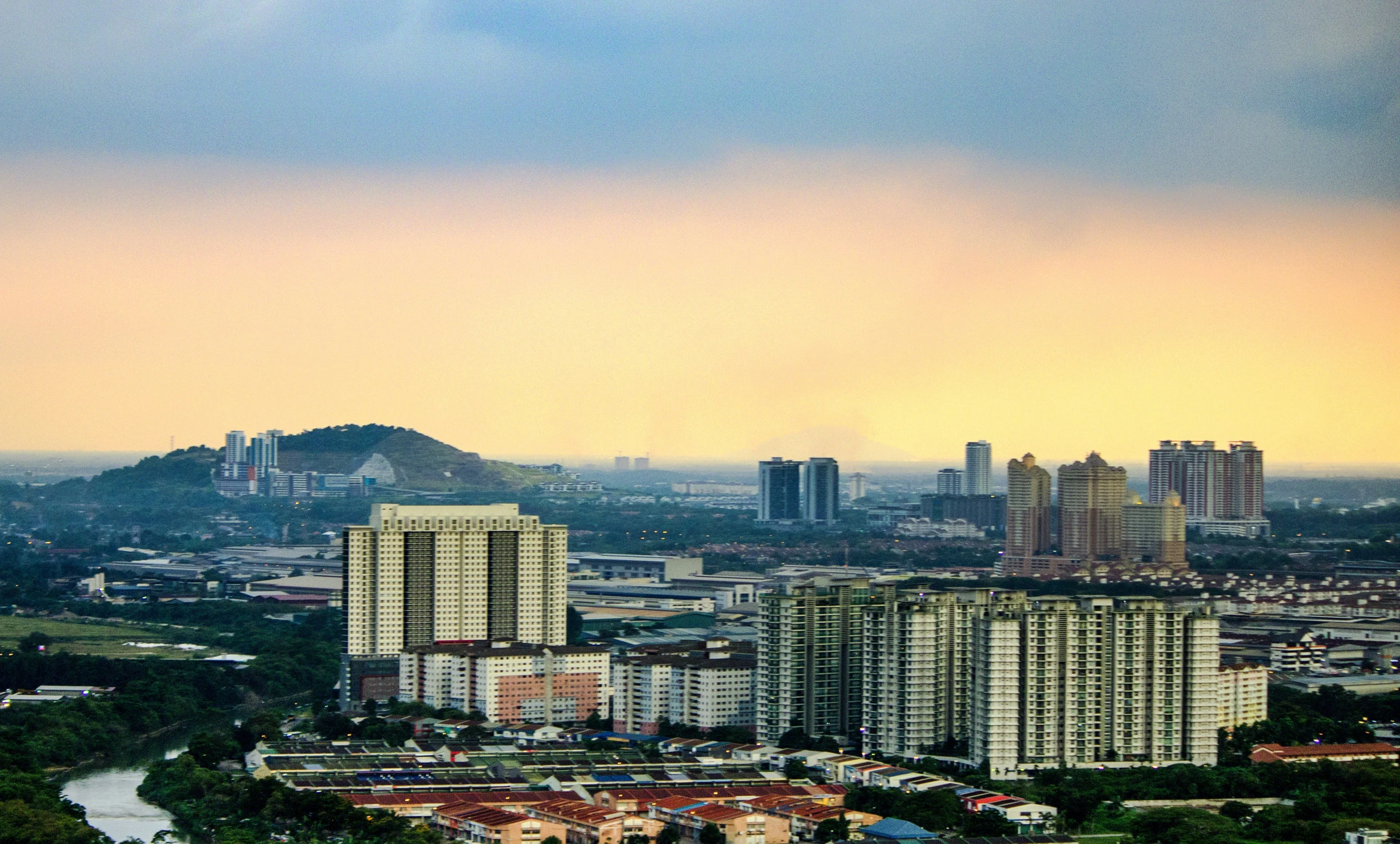 tall buildings sit on a city hill near a lake