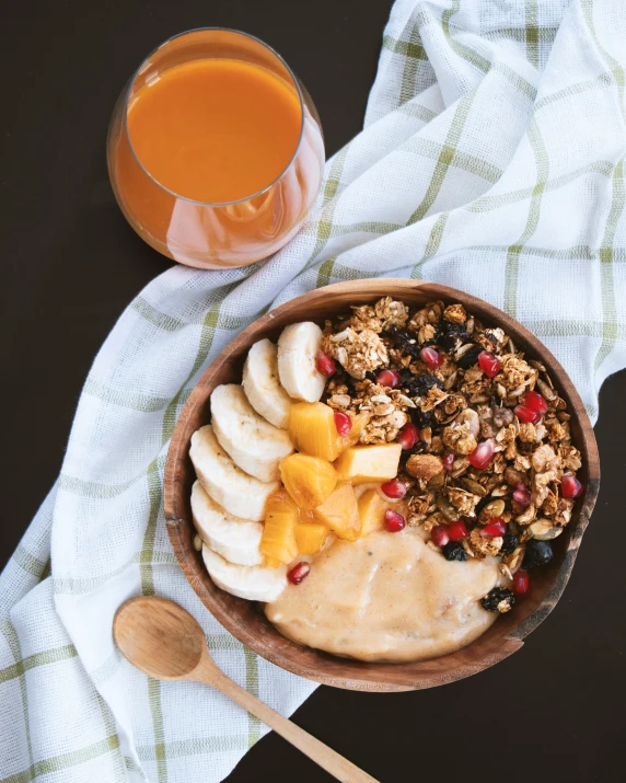 a bowl of granola, fruit, and milk with a spoon