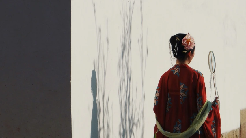 a young woman in a kimono holding a tennis racket