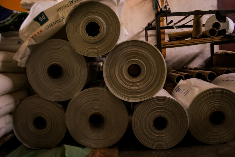 lots of rolled up rolls of paper in a warehouse