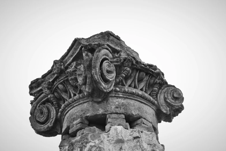 the top of a stone column in black and white