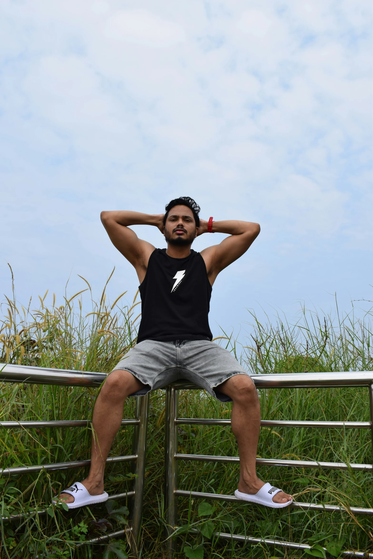 man sitting on a fence wearing a black shirt