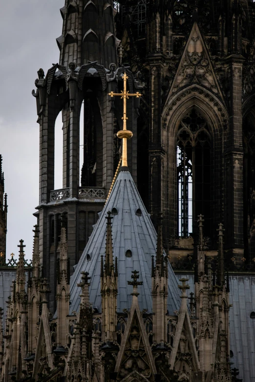 a view of a cross atop a church with spires