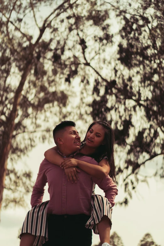 couple emcing each other under a tree