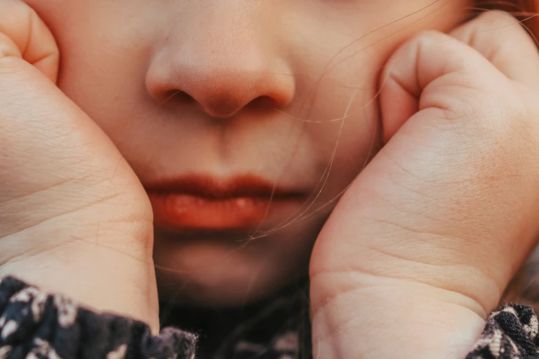 a close up of a woman touching her face