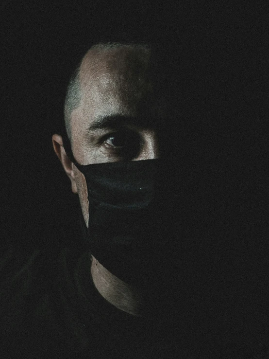 a man wearing a face mask in the dark