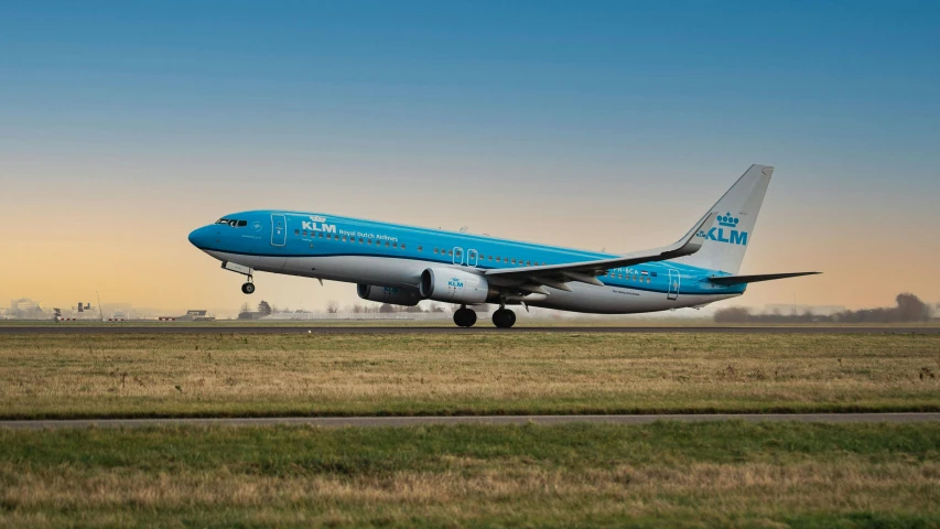 the blue airplane is preparing to take off from the runway
